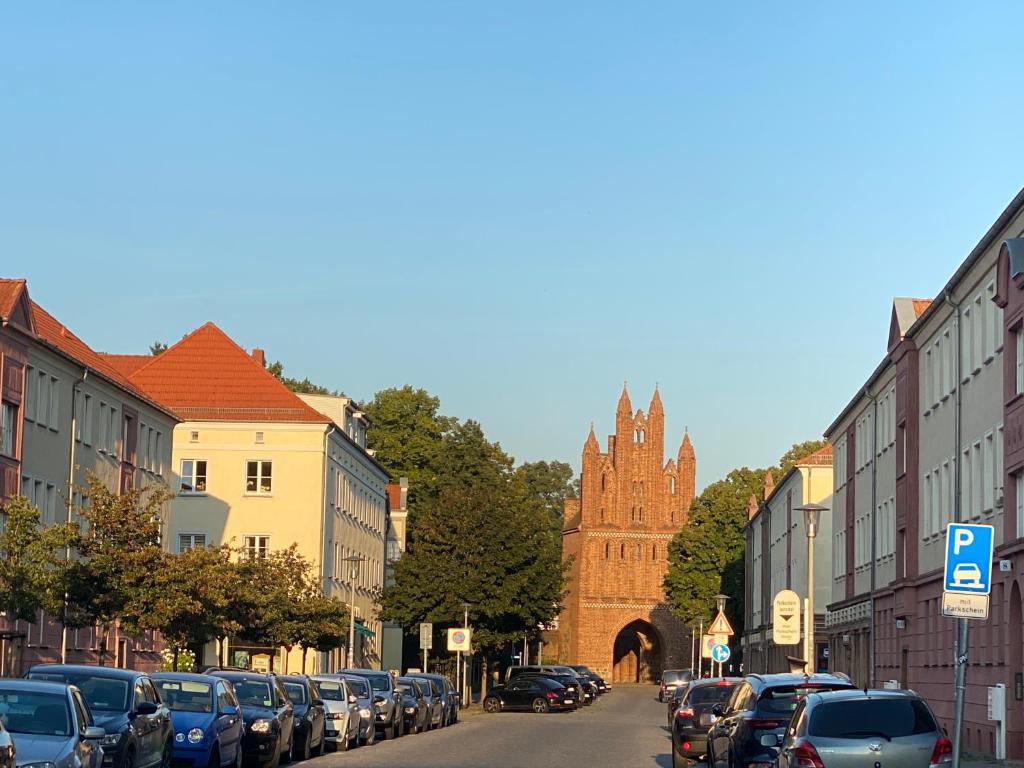 新勃兰登堡Mitten im Herzen von Neubrandenburg的一条有停车车和教堂的城市街道