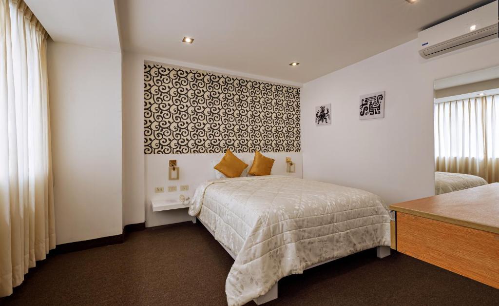 特鲁希略Hotel Médano的一间卧室设有一张床和一面墙