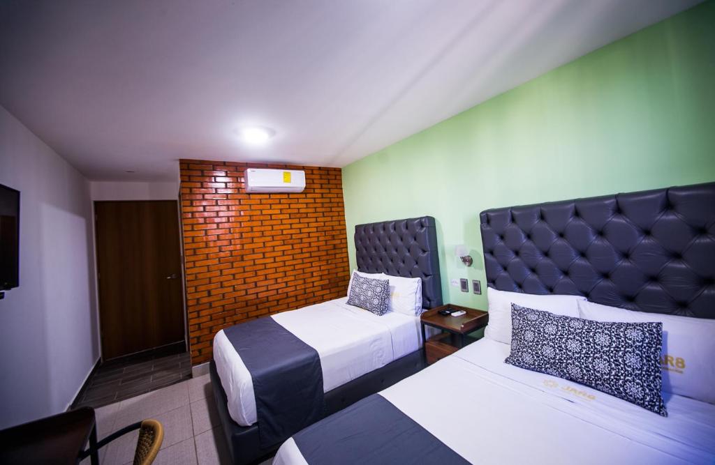 韦拉克鲁斯Hotel Jar8 Acuario enfrente al Acuario de Veracruz的酒店客房设有两张床和床头板