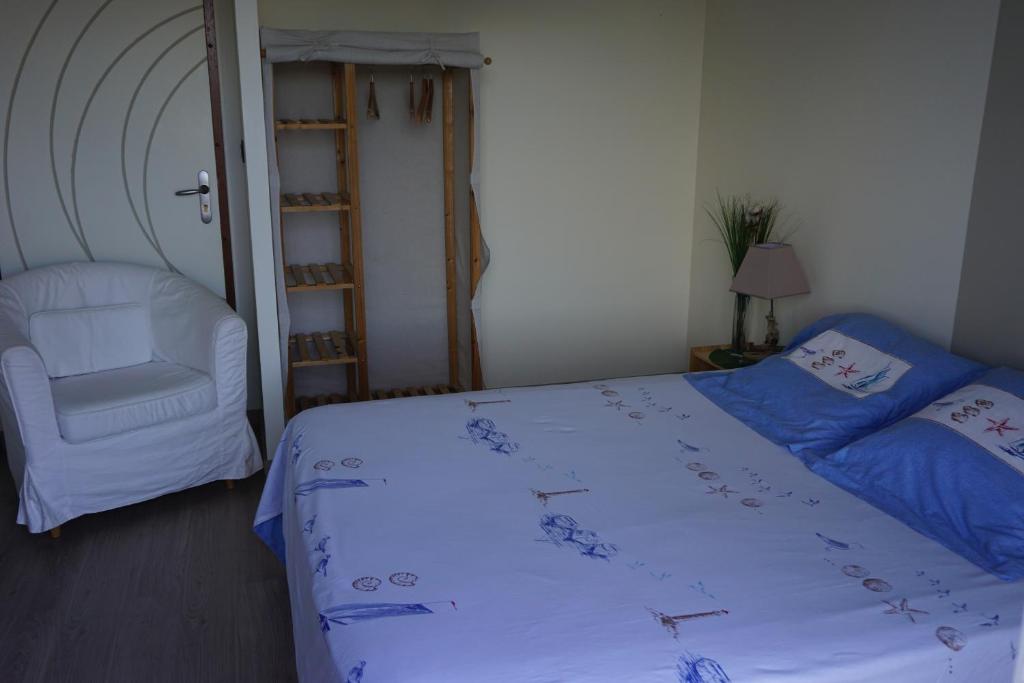 吉伦特河畔梅谢尔Chambre d'hôtes le Berceau的一间卧室配有一张床、一把椅子和梯子