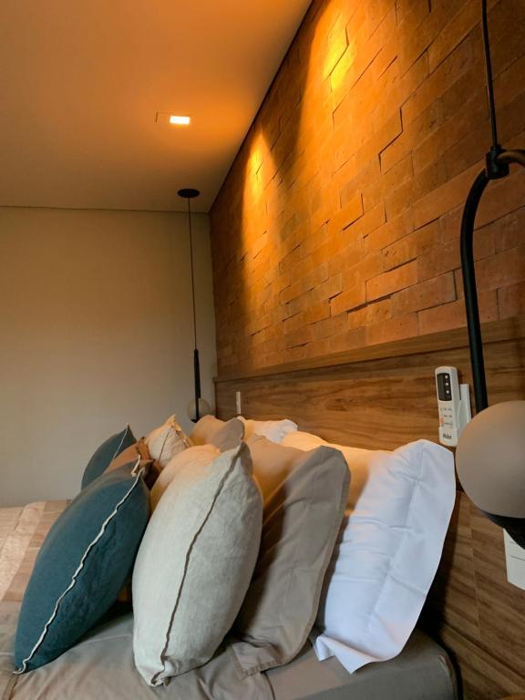 伊泰帕瓦Granja Brasil的一间卧室配有带枕头的床和砖墙