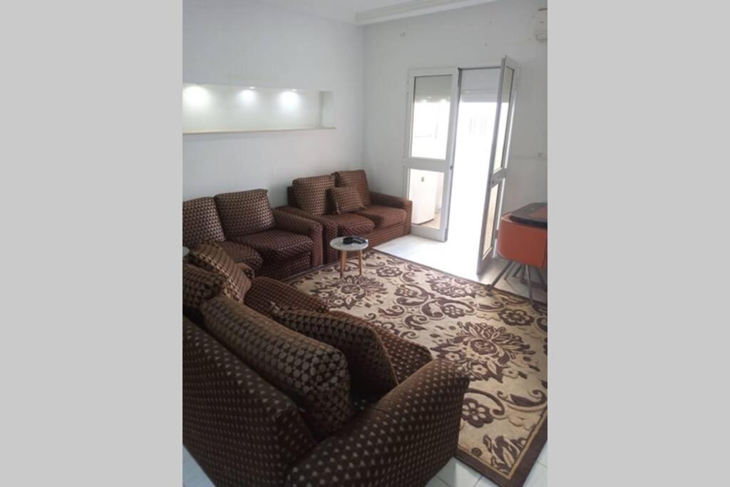 哈马马特Appartement à louer à Hammamet nord的带沙发和镜子的客厅