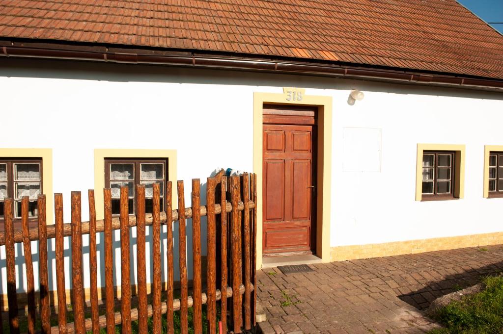MezimestiChalupa Barborka的白色的房子,设有木门和围栏