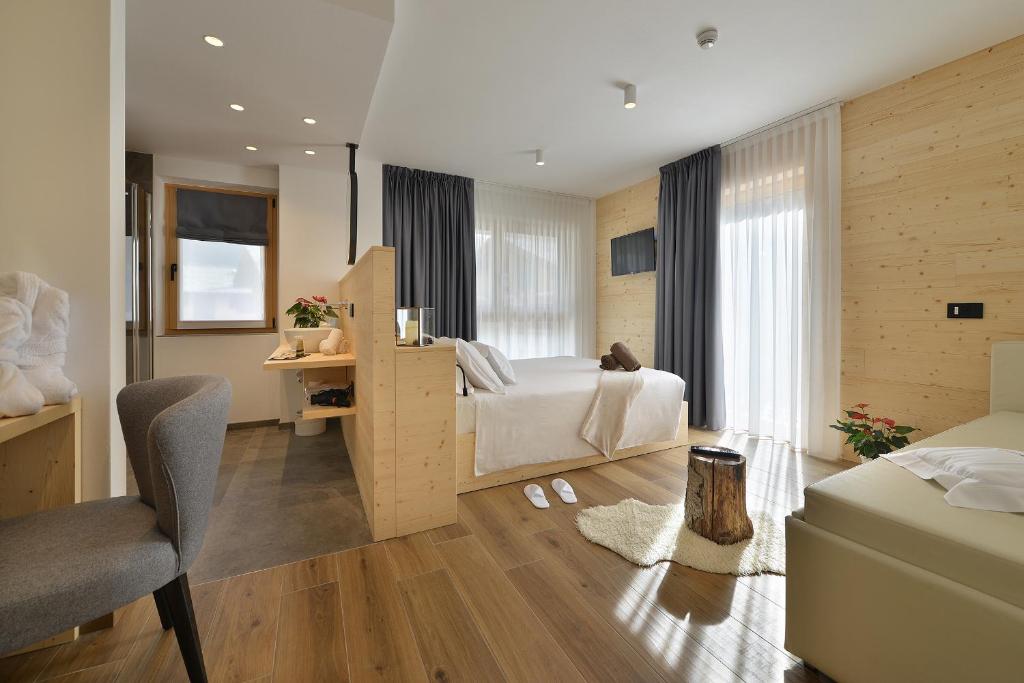 利维尼奥Hotel Valtellina的一间卧室配有一张床、一张桌子和一把椅子