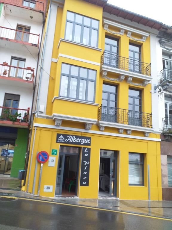 蒂内奥Albergue La Plaza的街道边的黄色建筑