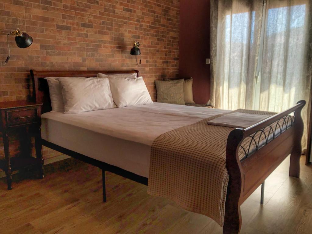 LechovoGuesthouse Monopati - Ξενώνας Μονοπάτι的砖墙客房内的一张大床