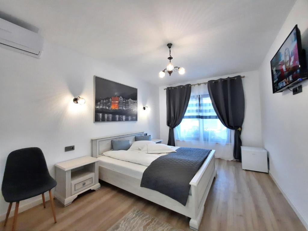 德瓦Casa Mora的一间卧室配有一张床、一把椅子和电视。