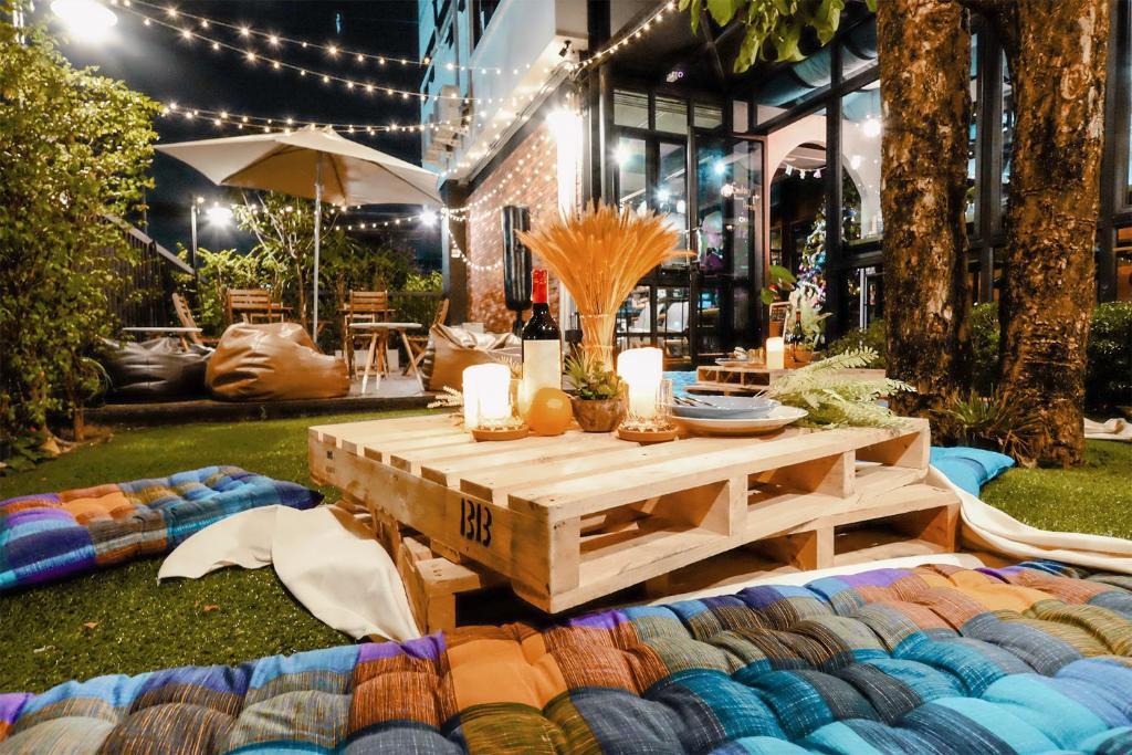 曼谷廊曼机场维哈旅舍的院子里的一张野餐桌,带毯子