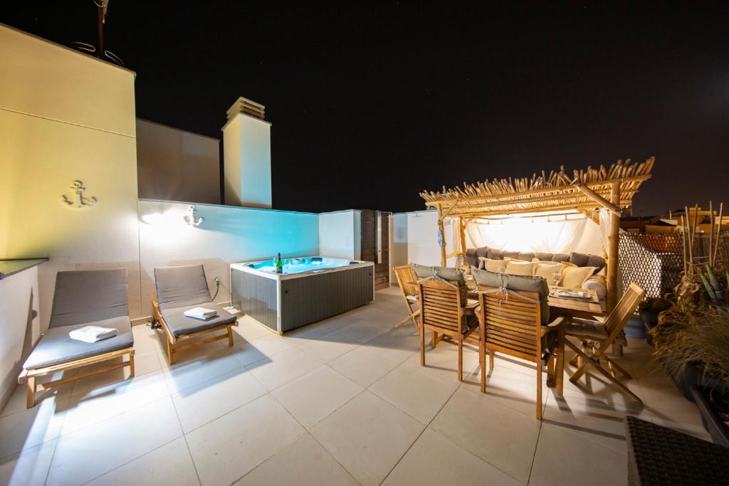 厄尔梅达诺MEDANO4YOU Tina's Jacuzzi Terrace Playa Chica的客厅配有桌椅和浴缸。