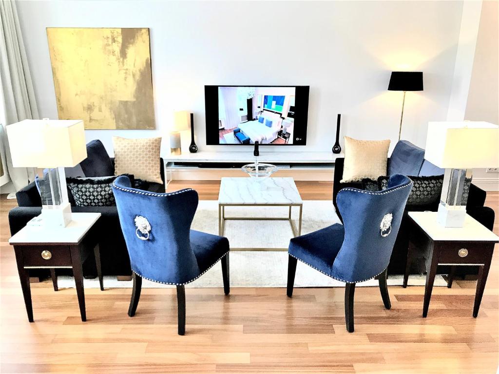 华沙Luxury Suites & Apartments MONDRIAN Market Square II的客厅配有蓝色椅子和沙发