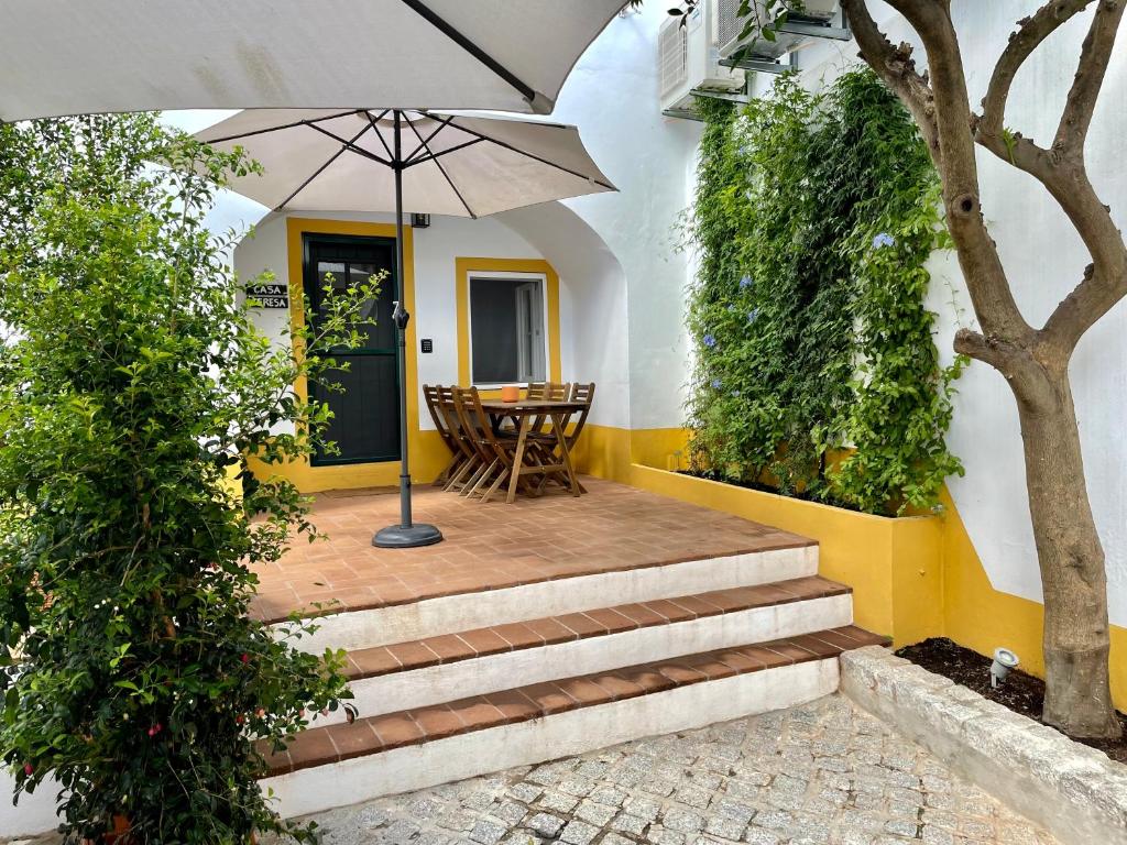 埃武拉Casa Teresa的房屋前设有带楼梯和遮阳伞的天井。