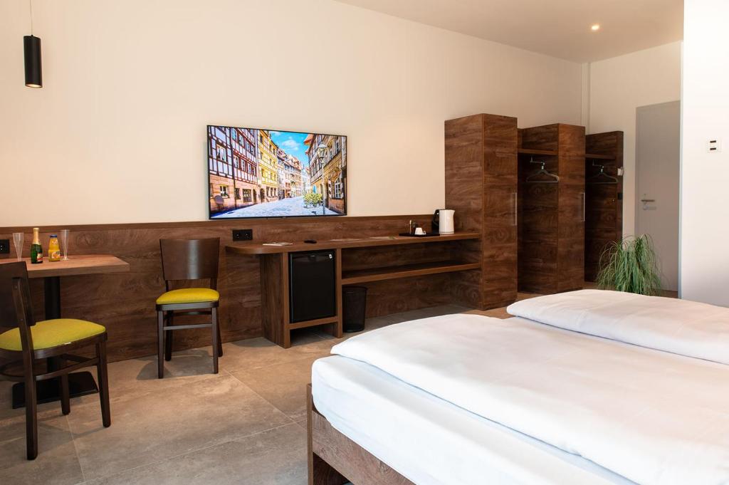 菲尔特Hotel Grüne Elster的一间卧室配有两张床和一张书桌及电视