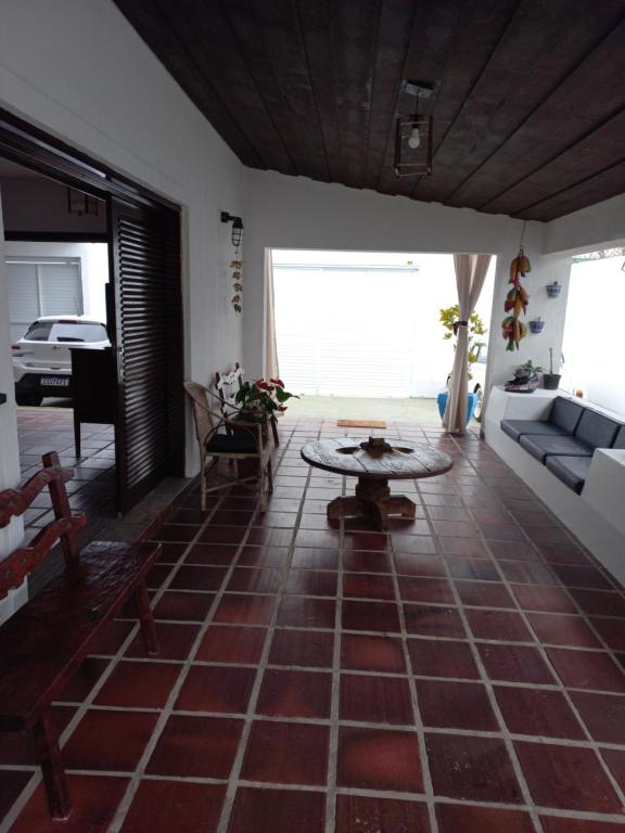 瓜鲁雅Pousada Sol da Manhã的客厅配有沙发和桌子