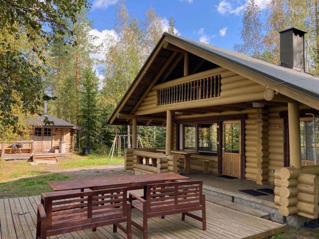 NyröläMökki Jyväskylä的小木屋设有2张长椅和1张野餐桌
