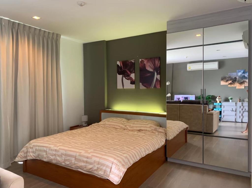 Ban Huai Sok NoiThe Valley Khao Yai的一间卧室配有一张带绿色墙壁的床