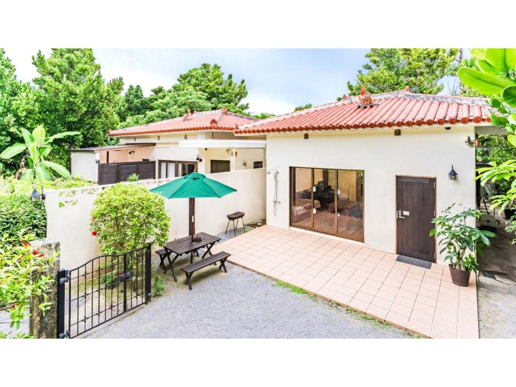 备濑Fukugi Terrace - Vacation STAY 61828v的房屋设有带桌子和遮阳伞的庭院