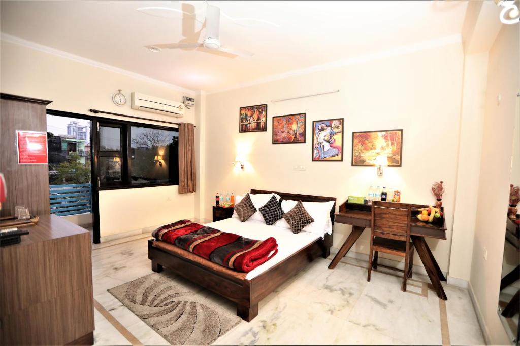 大诺伊达Bhambri Expo House的一间卧室配有一张床、一张桌子和一张书桌