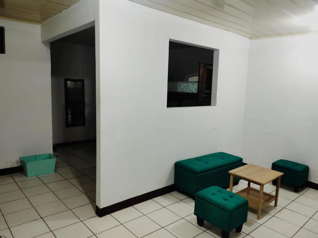 阿拉胡埃拉Departamentos Patricia的一间设有两张绿色椅子和一张桌子的房间