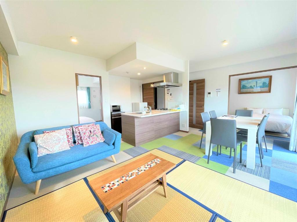 福冈A.T. Hotel Hakata的一间带蓝色沙发的客厅和一间用餐室