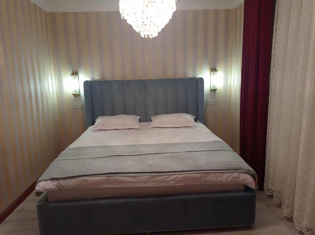 泰尔梅兹Comfortable Home Stay的一间卧室配有一张带吊灯的大床