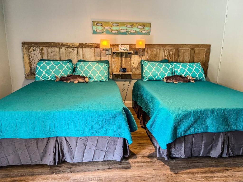 QuitmanReel Inn and Lodge的两张睡床彼此相邻,位于一个房间里