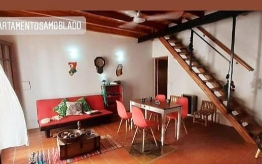 里奥夸尔托La Querencia Apart RC的客厅配有红色的沙发、桌子和椅子