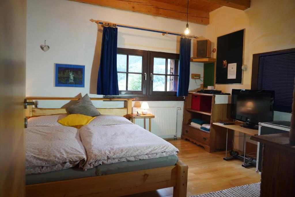 AltlassingWohnstudio in umgebauter Scheune的一间卧室配有一张带电视和书桌的床。