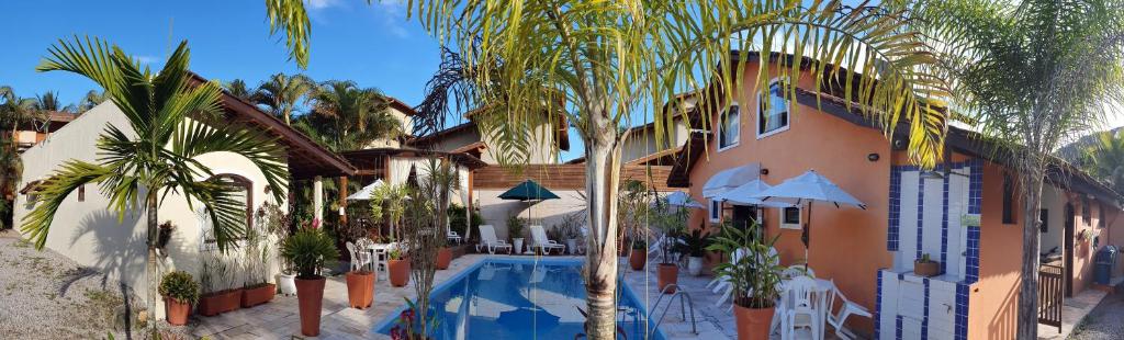 坎布里皮涅罗旅馆的一座带游泳池、棕榈树和大楼的度假村