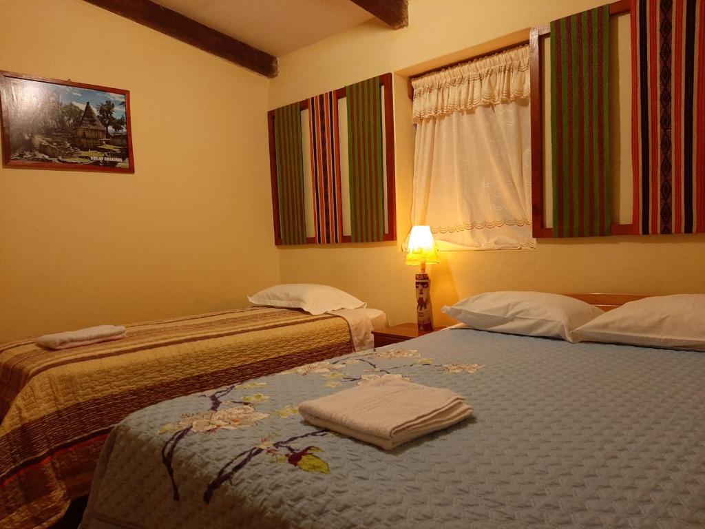 CocachimbaHealthy Stay Gocta的客房设有两张床、一盏灯和一扇窗户。