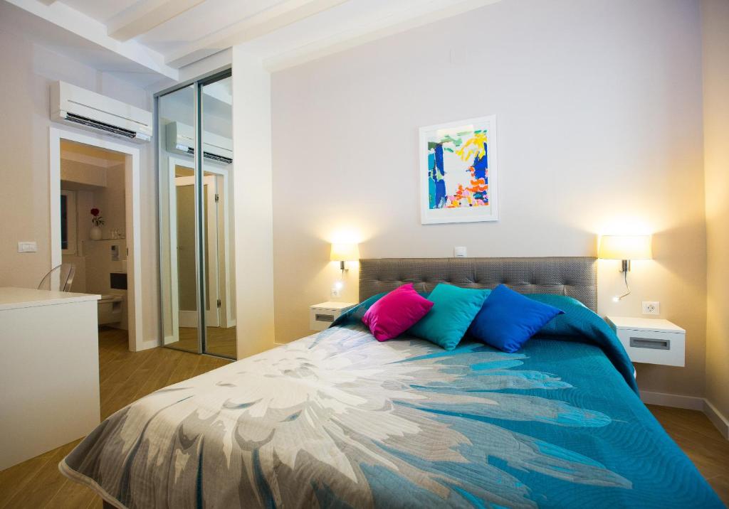 杜布罗夫尼克弗洛雷斯别墅客房酒店的一间卧室配有一张带蓝色和粉红色枕头的床