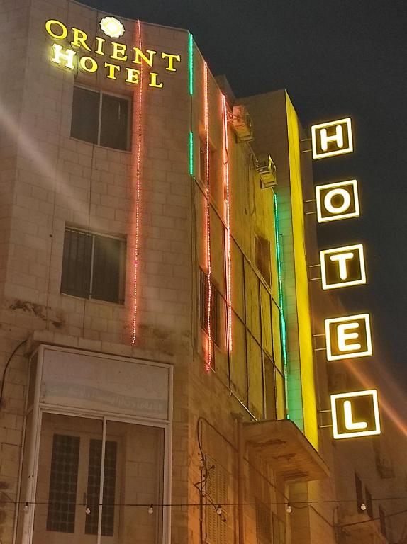 纳布卢斯Orient Hotel的楼边有 ⁇ 虹灯标志的酒店