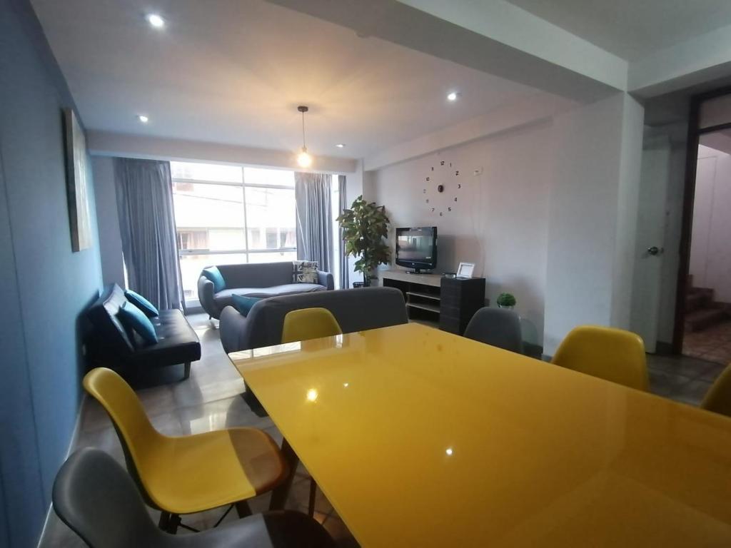 库斯科Cusco Cozy Apartment的客厅配有黄色的桌子和椅子