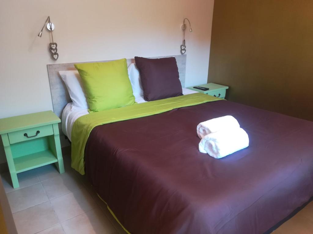 瓦戈兰斯appartement avec Jacuzzi hammam sauna privatisé au rez de chaussée ds maison à Voglans à 2 kilomètres du lac du bourget en Savoie entre Chambéry et Aix les Bains cure thermale的一间卧室配有一张床,上面有两条毛巾