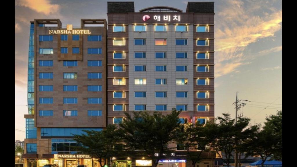 丽水市Yeosu Beach Hotel的一座高大的建筑,上面有标志