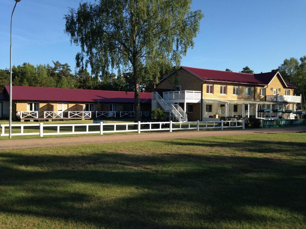 布达Böda Hotell的田野前有白色围栏的房子