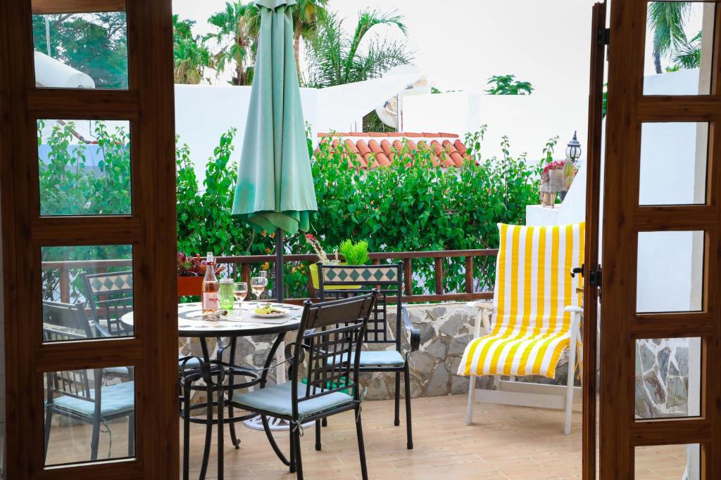 阿德耶Los Geranios, Close to BEACH, Puerto Colon, YellowCat 2的庭院配有桌椅和遮阳伞。