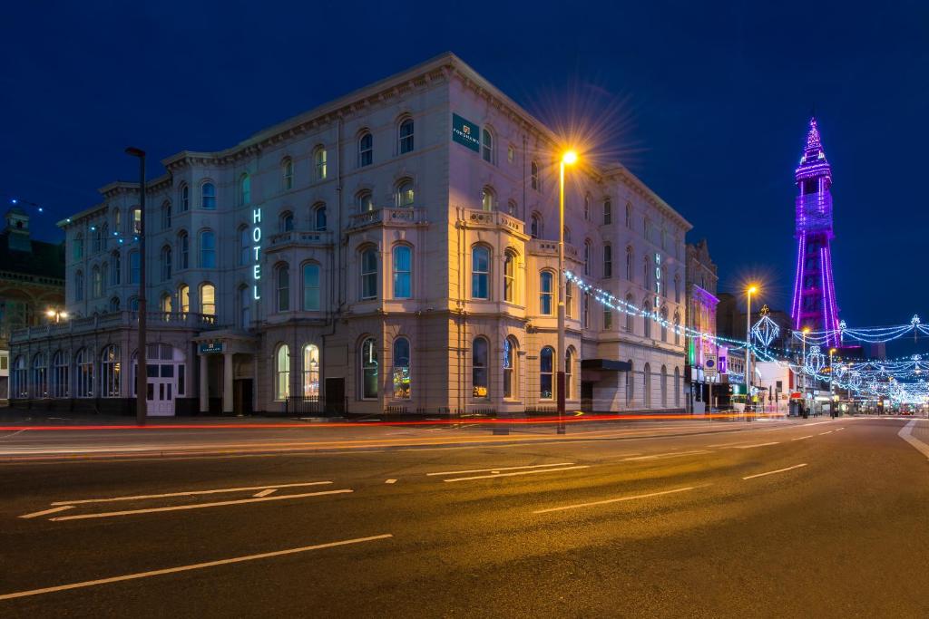 布莱克浦Forshaws Hotel - Blackpool的街上的一座建筑,晚上有艾菲尔铁塔