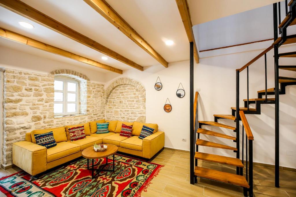 科帕罗Vila Leon - Old Qeparo的客厅设有黄色沙发和楼梯。