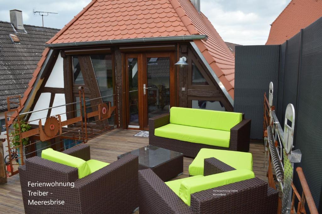 埃根斯泰因-列奥波德港Ferienwohnungen Treiber的一座带绿椅的甲板的房子