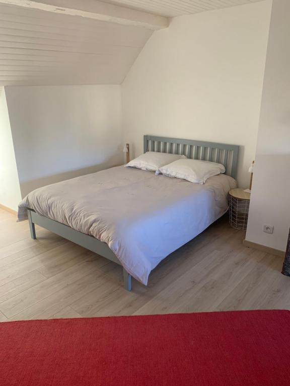 拉瓦勒Le logis du Vassal的一间卧室配有一张红色地毯的大床