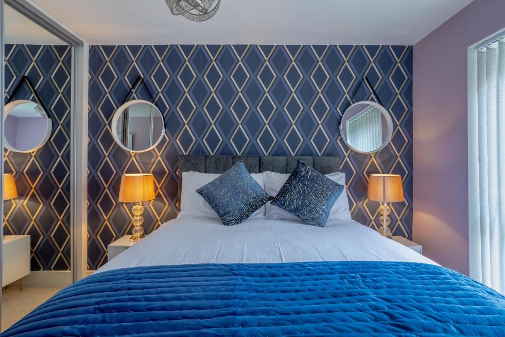 金斯兰利LillyRose Apartments - Hemel Hempstead, Free Parking, Free Wi-Fi的一间卧室配有一张蓝色的床和两面镜子