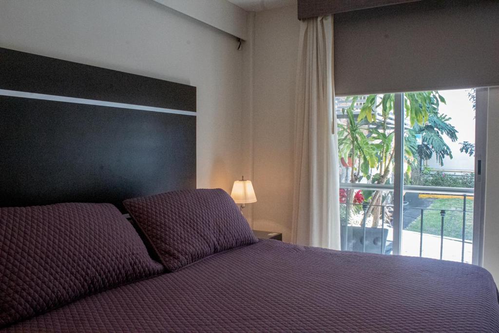 科阿特佩克科特佩圣何塞广场酒店的一间卧室设有一张床和一个大窗户