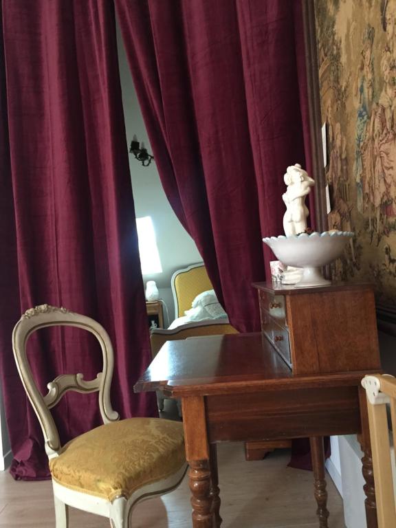 Sallaumines罗玛内公寓的一间带桌椅和红色窗帘的用餐室
