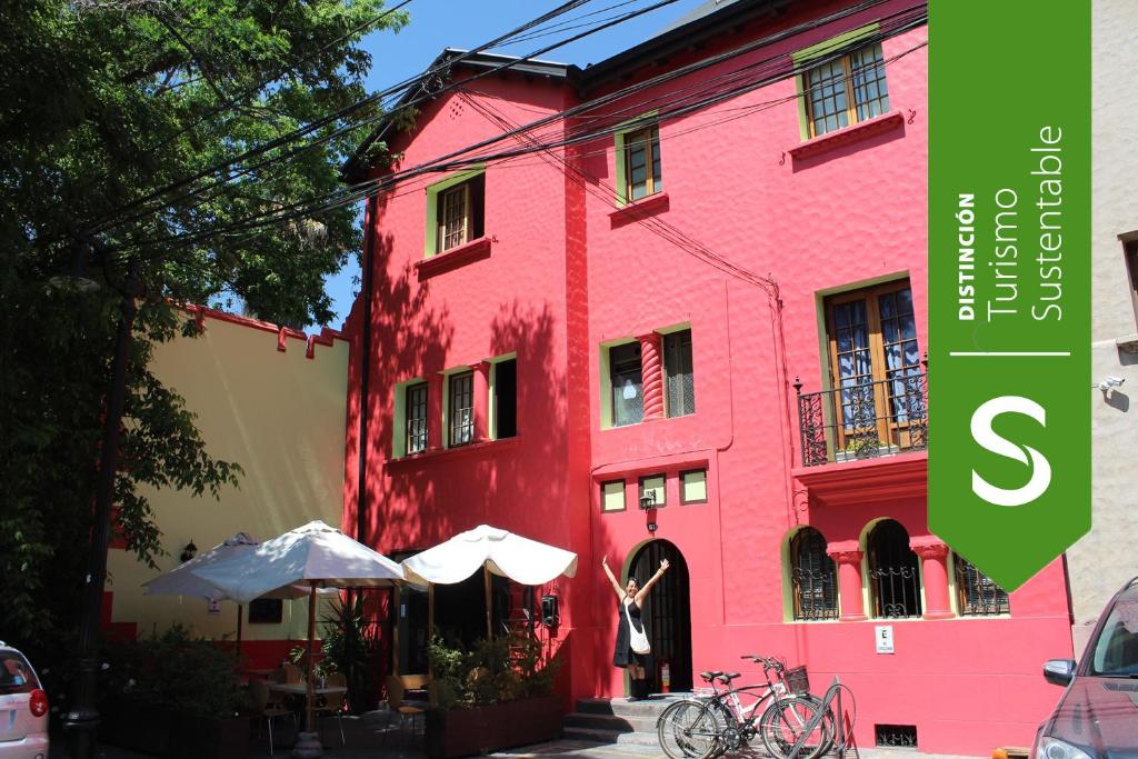 圣地亚哥阿吉青年旅社的红楼旁边的粉红色建筑