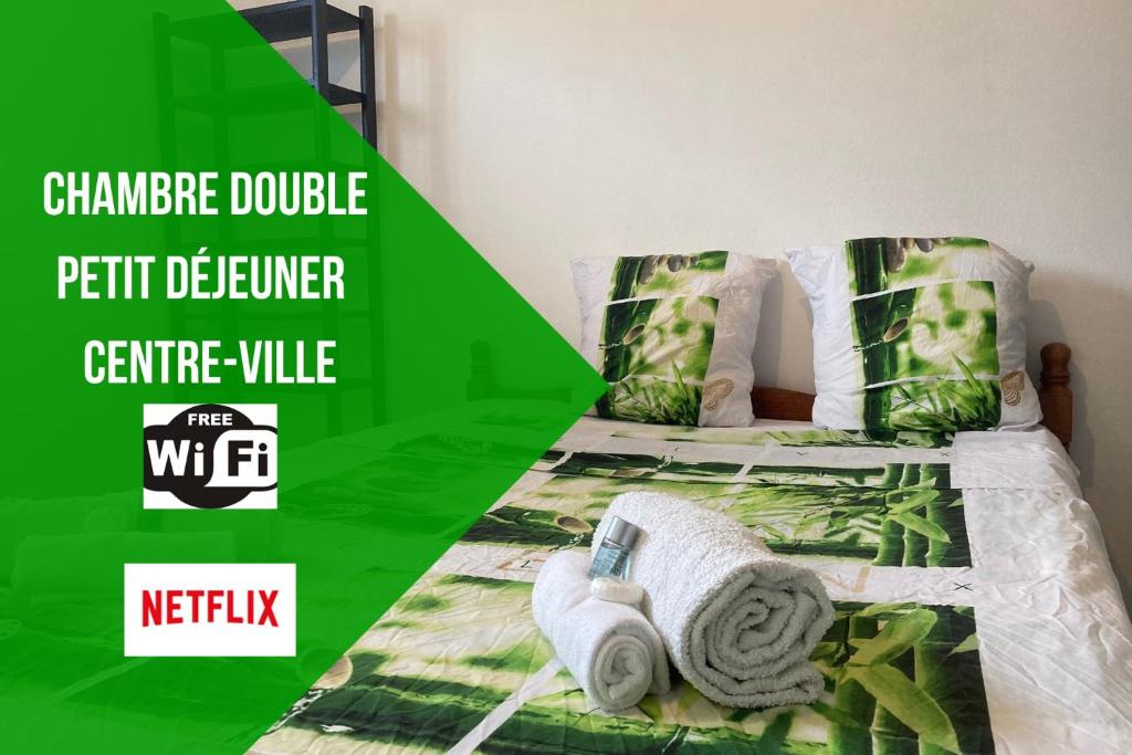 马罗尼河畔圣洛朗Le Carbet du Centre-Ville - CLIM-CENTRE-VILLE-WIFI-PARKING-NETFLIX的一张绿色和白色的床,上面有毛巾