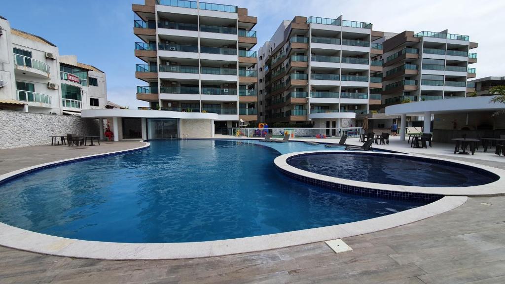阿拉亚尔-杜卡布Apartamento Ninho das Gaivotas - Praia dos Anjos Residence - 2 Vagas的大楼前的大型游泳池