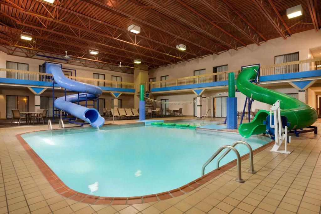 法戈Ramada by Wyndham Fargo的一座大楼内带水滑梯的大型游泳池