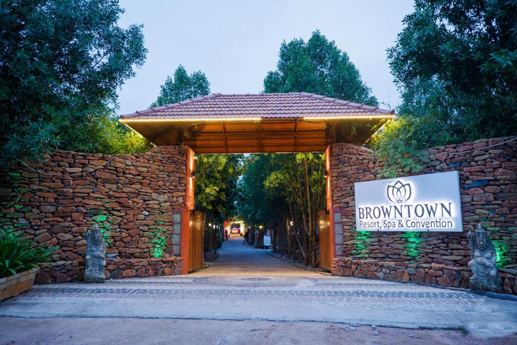 海得拉巴Brown Town Resort & Spa的建筑物入口,上面有标志