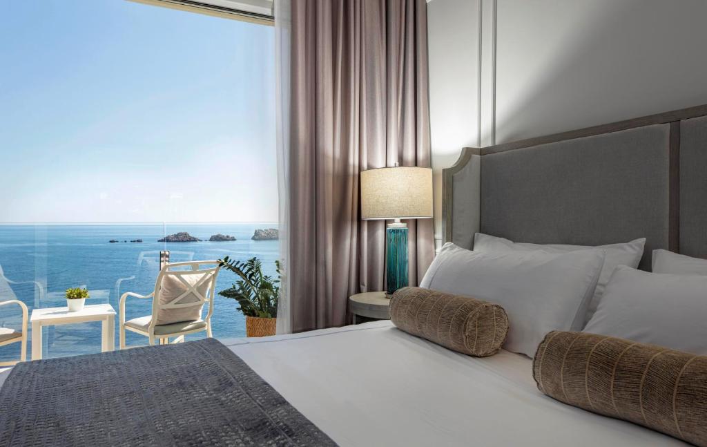 杜布罗夫尼克皇家棕榈酒店的一间卧室设有一张床,享有海景