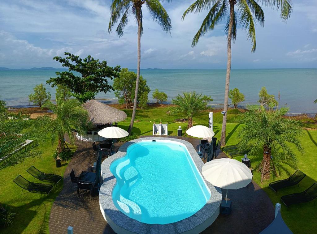 象岛Beachfront Pool Villa and Apartment的享有带椅子和遮阳伞的游泳池的上方景色